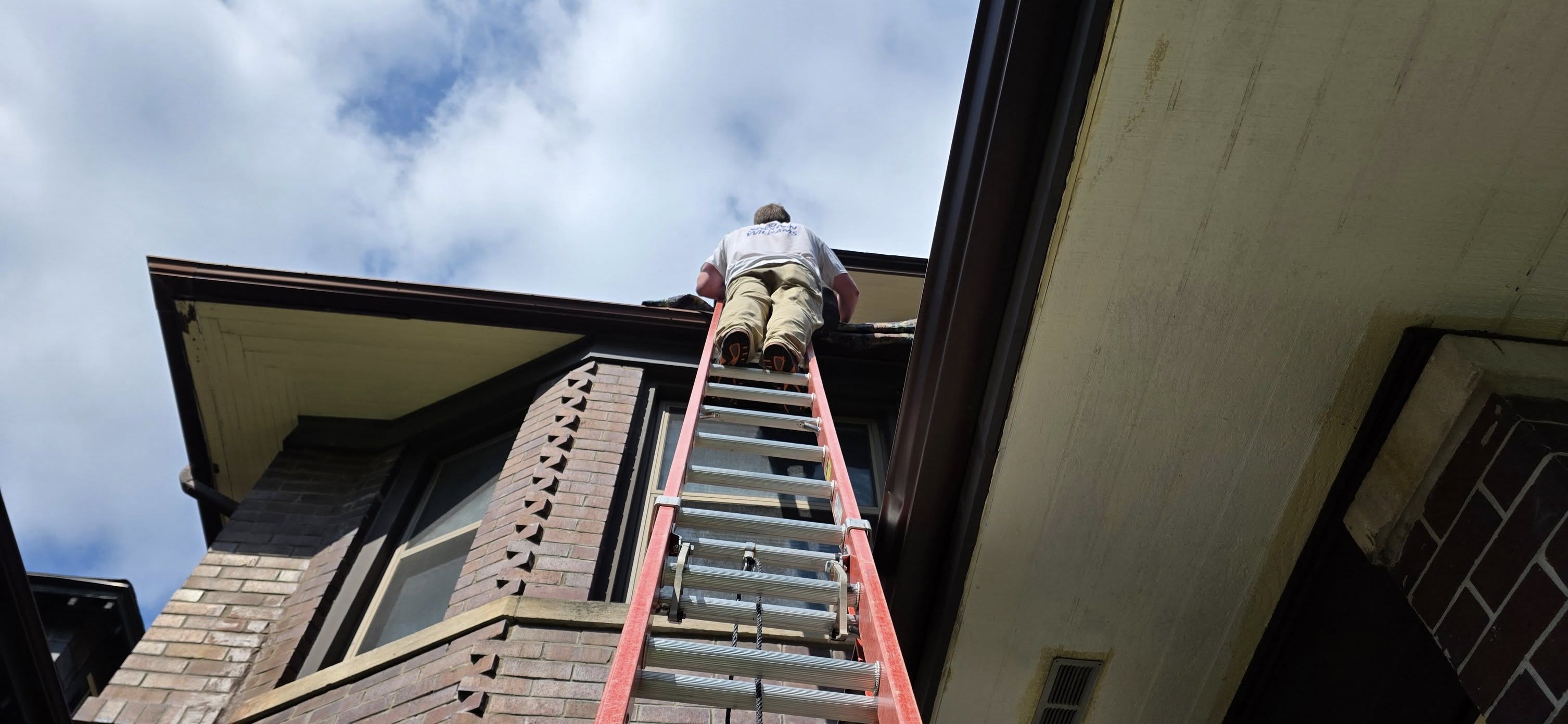 Painter on ladder working on home exterior